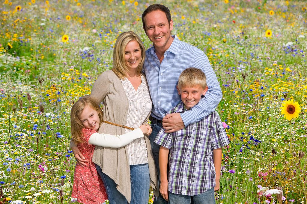 Portrait,Of,Family,On,Walk,Through,Field,Of,Summer,Flowers