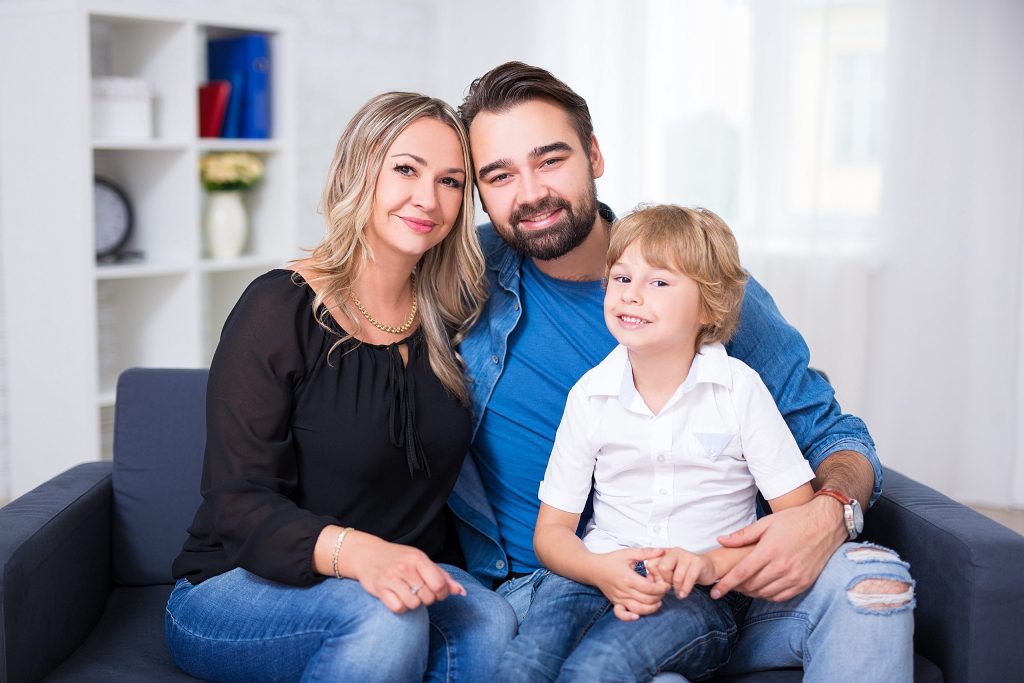 Happy,Family,Portrait,-,Couple,And,Little,Son,Sitting,On